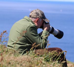 Stephen Smith - Smith Wild Photo practising photography, sat on the cliffs overlooking the Moray Firth